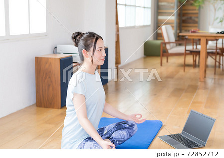 リビングでオンラインヨガする若い女性 リビングでオンラインヨガする若い女性 72852712