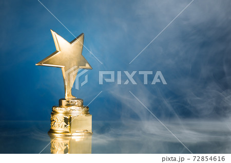 gold star trophy in smoke, blue background 72854616