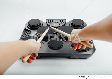 hands playing on portable electronic drums, white background hands playing on portable electronic drums, white background 72855209