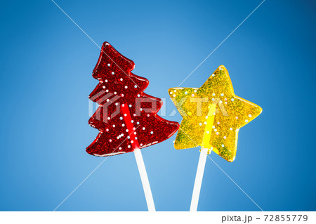 red Christmas tree and yellow star candy, blue background red Christmas tree and yellow star candy, blue background 72855779
