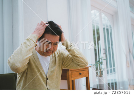 頭を抱える60代男性 72857615