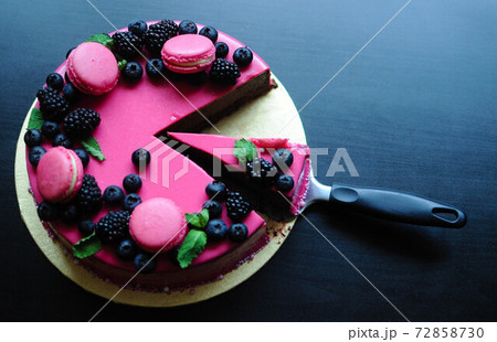 Delicious cake with fresh strawberries, raspberries, blueberry, currants. cut piece of cake and blade on wooden background. 72858730