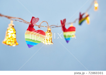 Lgbt valentine's day concept, rainbow heart on garland on blue background, copy space Lgbt valentine's day concept, rainbow heart on garland on blue background, copy space 72860301