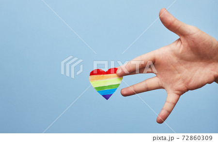 Lgbt valentine's day concept, rainbow heart in hand on blue background, copy space Lgbt valentine's day concept, rainbow heart in hand on blue background, copy space 72860309