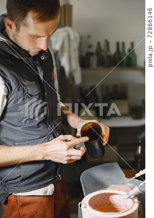A man processes a bottle into a glass 72866146