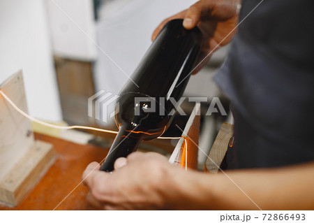 A man processes a bottle into a glass 72866493