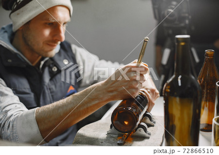 A man processes a bottle into a glass 72866510