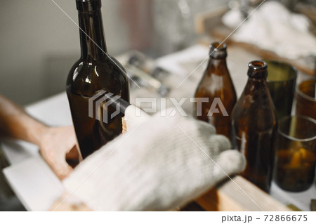 A man processes a bottle into a glass 72866675