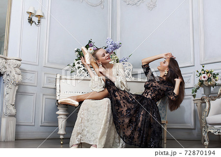 young pretty brunette ballet dancer at piano with blond woman in luxury royal interior, lifestyle rich people concept young pretty brunette ballet dancer at piano with blond woman in luxury royal interior, lifestyle rich people concept 72870194