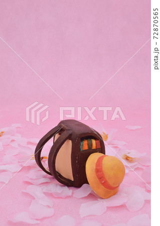ピンクの背景に桜と粘土で作られた茶色のランドセル 黄色い帽子の写真素材