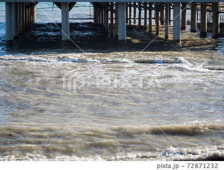 Sea pier with columns on the beach 72871232