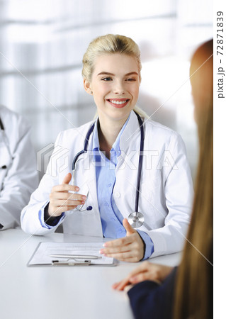 Woman-doctor with male colleague are consulting patient woman while sitting at the desk in modern clinic. Perfect medical service, medicine concept 72871839