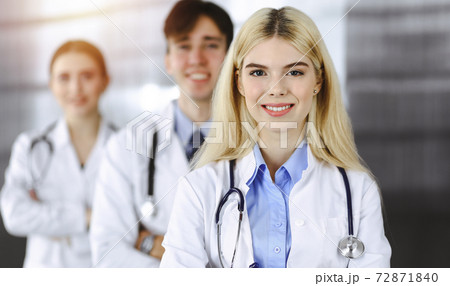 Group of three young doctors standing as a team with arms crossed in modern clinic and ready to help patients. Medicine concept 72871840