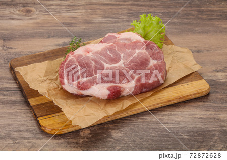 Raw pork steak over wooden board Raw pork steak over wooden board 72872628