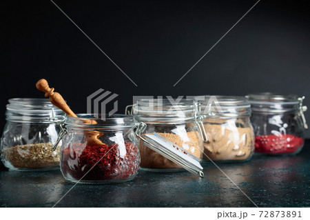 Various Oriental spices and herbs in glass jars. 72873891