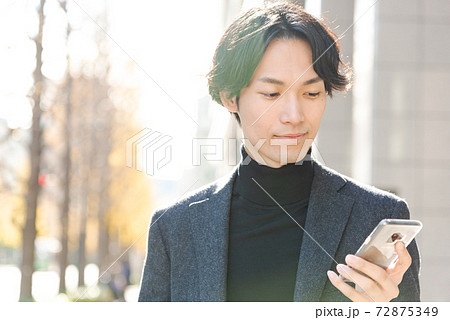 スマートフォンを操作する男性 冬 都会 72875349