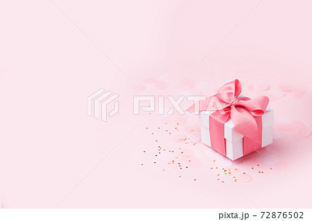 Holiday pink background with gift, white satin bow, ribbon. Valentine's Day, Happy Women's Day, Mother's Day, Birthday, Wedding, Christmas. space for text, banner, flyer 72876502