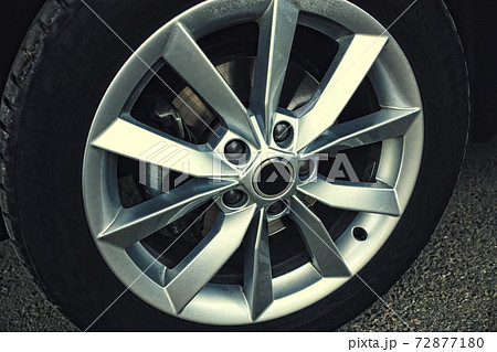 New car wheel with alloy wheel. Detail of the car on a gray asphalt background. New car wheel with alloy wheel. Detail of the car on a gray asphalt background. 72877180