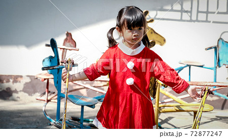 little Girl kid wearing Santa Claus uniform in the playground, Kid having fun on Christmas holiday time 72877247