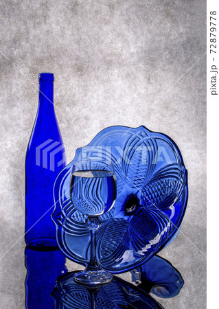 Still life with blue bottle, glass and blue vase on gray background Still life with blue bottle, glass and blue vase on gray background 72879778