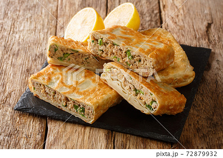 Arabic Mutabbaq stuffed with lightly spiced mince meat, herb and egg. closeup in the board. horizontal 72879932