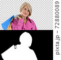 Beautiful senior woman in trench coat holding shopping bags, Alp 72880089