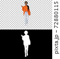 Smiling african american woman with headphones walking listening 72880115