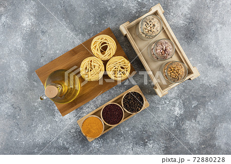 A bottle of oil with raw nest pasta and spices 72880228
