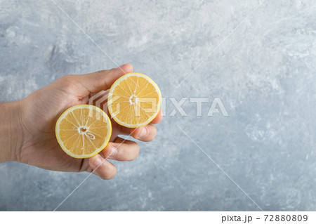 Man holds half cut fresh juicy lemons 72880809