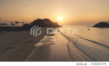 Sun silhouette of mountain with palm tree. Tropic cliff island at sea bay aerial. Ocean gulf waves 72884579
