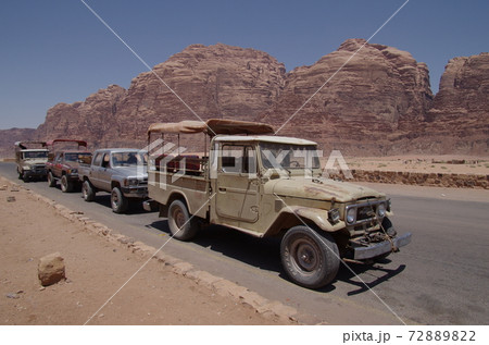 ヨルダン アカバ 大砂漠ワディラムの遊牧民の村に停車するランドクルーザーの車列と岩山の写真素材 72