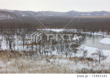 雪降る釧路湿原と釧路川 72893181