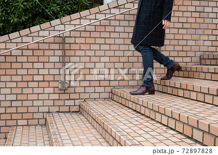 レンガの階段の降りる若い女性【冬】 72897828