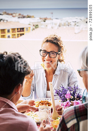 Happy family meeting at lunch with parents and friends after lockdown coronavirus health emergency - cheerful people together eating and drinking at home with city and ocean view Happy family meeting at lunch with parents and friends after lockdown coronavirus health emergency - cheerful people together eating and drinking at home with city and ocean view 72899105