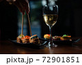 Hand, chopsticks, sushi set and white wine on dark background 72901851