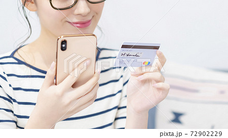 スマートフォンとカードを持つ若い女性 72902229