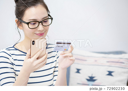 スマートフォンとカードを持つ若い女性 スマートフォンとカードを持つ若い女性 72902230