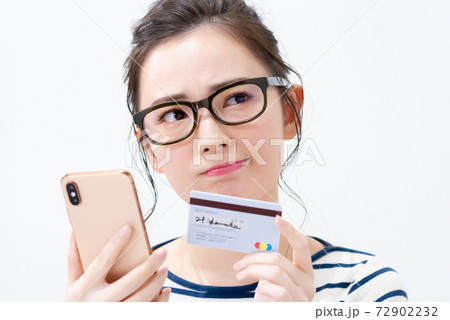 スマートフォンとカードを持つ若い女性 72902232