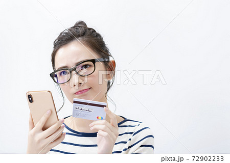 スマートフォンとカードを持つ若い女性 スマートフォンとカードを持つ若い女性 72902233