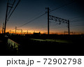 茜色の夕日を背にした架線 72902798