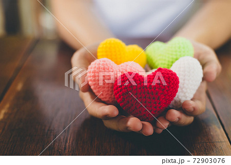 Mixed colors yarn heart on giving hands. Close up of colorful handmade. Healthy heart donation and health care concept. Valentine romance love forever theme Mixed colors yarn heart on giving hands. Close up of colorful handmade. Healthy heart donation and health care concept. Valentine romance love forever theme 72903076