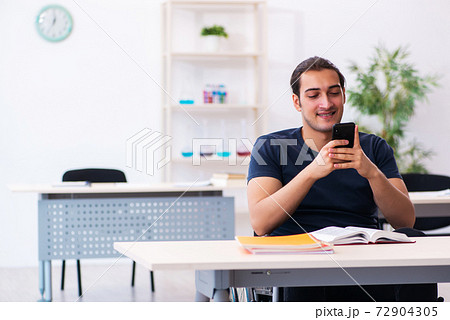 Young male student in wheel-chair preparing for exams Young male student in wheel-chair preparing for exams 72904305