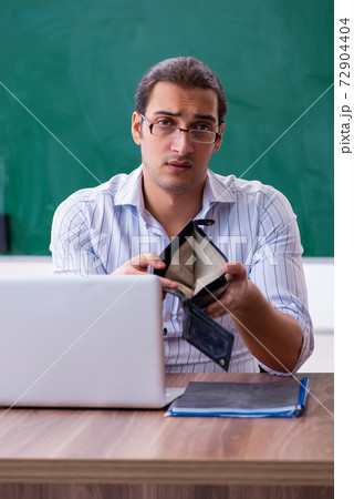Young male teacher in remuneration concept Young male teacher in remuneration concept 72904404