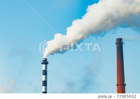 Chimney smoke at factory against blue sky 72905032