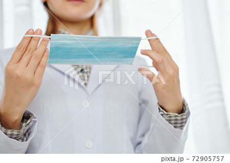 Doctor putting on protective mask Doctor putting on protective mask 72905757