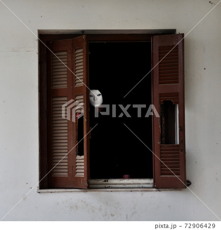 masked figure and broken window shutter 72906429