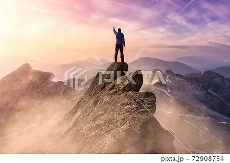 Man on top of a Mountain Cliff 72908734