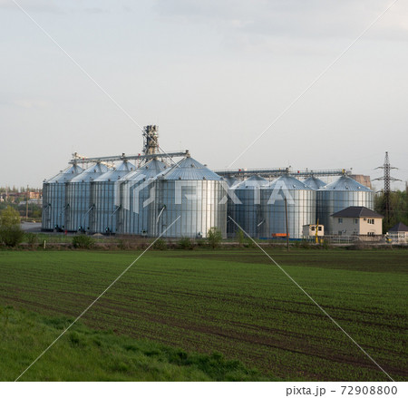 Grain elevators with green spring field in foreground Grain elevators with green spring field in foreground 72908800