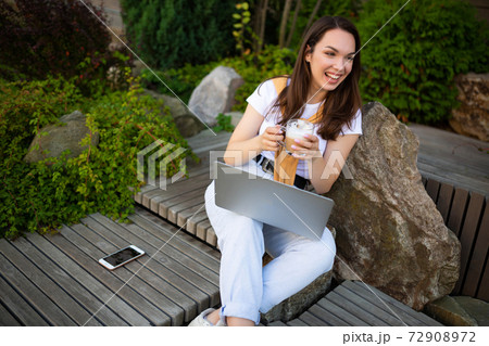 young business woman drinking coffee and working freelance on the street 72908972
