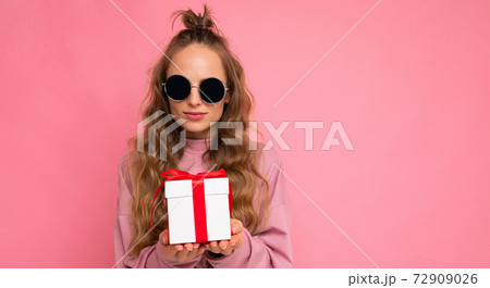 Pretty happy young blonde curly woman isolated over pink background wall wearing pink sport clothes 72909026
